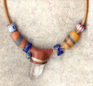 Chocolate buckskin wrap over Arkansas quartz crystal; accented wih blue antique glass zigzag beads and chevrons on 30